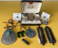 Full lot laid out showing all pendants, jewelry items, mezuzah cases, and keychains