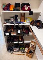Full shelving unit showing belts, hats, shoes in boxes, shoe care items and umbrella laid out