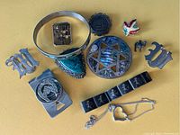 Photo showing all Sterling Silver jewelry pieces together on yellow background: includes brooches, pins, money clip, bracelet, necklace and ring.