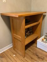 Side view showing the flat front design and one open shelf filled with fabric items