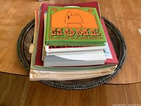 Stack of assorted Charlie Brown and Christmas themed books resting on a silver decorative plate tray.