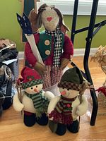 Group photo of all three plush Christmas standing figures including two snowmen and one moose.