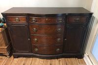 Front view of the vintage mahogany sideboard showing serpentine front, two side cabinets, and metal handles.