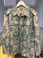 Front view of 1995 Ukrainian Armed Forces TTsKO Butan military jacket showing camo print, chest pockets, shoulder epaulets, and button front.