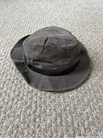 Side and top view of dark brown waxed cotton Eddie Bauer hat showing ventilation eyelets and full shape.