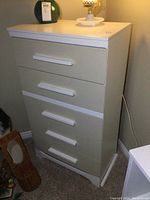 Front angle view of the tall painted wood dresser with five drawers and wide horizontal handles.
