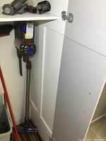 Full assembled vacuum and attachments leaning in closet