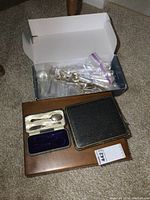 Wood chest with open shoebox containing 8 pieces of Rogers flatware, two vintage flatware cases with flatware inside.