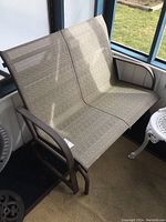 Front view of bench showing two mesh seats and metal gliding frame