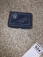 Original black box with white Smith & Wesson logo and text on carpet floor.