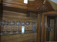 Shelf with 7 stemware glasses and a crystal pitcher on the right
