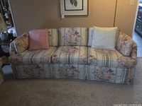 Front view of floral patterned sofa with removable cushions and 2 accent pillows, showing full length and seating area.