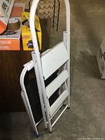 Folded 2-step metal folding step stool, white, showing paint and rubber foot caps