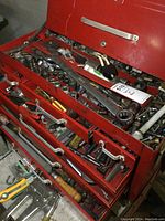 Full view of open upper toolbox drawer showing sockets, wrenches, bits and other tools