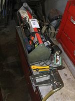Wide view of the metal tool caddy filled with various hand tools including hammer and vise