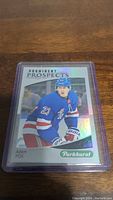 Front view of Adam Fox rookie hockey card from Parkhurst Prominent Prospects series, showing player in blue Rangers uniform.