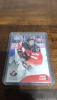 Front side of Connor McDavid rookie hockey card in a protective case, showing player in action wearing Team Canada Junior jersey number 17.