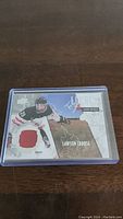 Front of the Lawson Crouse hockey jersey card showing player image and embedded red jersey patch in protective case.