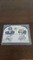 Front view of signed hockey card showing Matt Stajan and John Mitchell headshots with their autographs in blue ink.