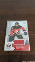 Front view of Meaghan Mikkelson hockey card with red jersey patch, showing Canada Women design and player in red uniform