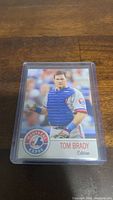 Front of the baseball card showing Tom Brady in catcher uniform for Montreal Expos, in plastic holder.