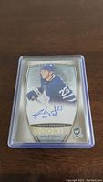 Front view of Travis Dermott Rookie Autograph hockey card, showing player in Toronto Maple Leafs jersey, with autograph and number 23.
