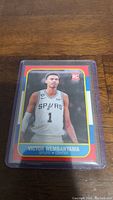 Front of Victor Wembanyama basketball card in protective sleeve showing him in Spurs jersey.