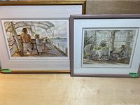 Two framed prints by Trisha Romance displayed side by side, showing the boat scene and the conservatory scene.