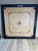 Full view of the square carrom board showing playing surface, design, and corners