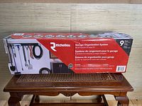 Photo of the Richelieu garage organization system box showing the product name and illustrations of the type of tools it is designed to hold.