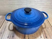 Front view of round Dutch oven with lid on, showing cobalt blue exterior and dual handles