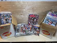 Two cardboard boxes filled with Sports Illustrated magazines, some stacked in front.