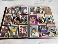 Photo showing multiple baseball cards inside the album pages, featuring various players and teams in color.