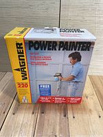 Front view of the boxed Wagner Power Painter Sprayer model 220 showing branding, model number, and usage image.