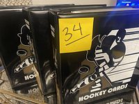 Three black binders of hockey cards with hockey player artwork and 'HOCKEY CARDS' text on front.