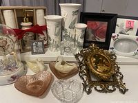 Photo shows variety of love themed items including ceramic vases, trinket dishes, framed prints, and clocks.