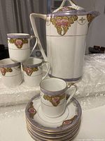 Full set displaying 1 lidded pot, 4 cups stacked, 6 saucers stacked with one cup set on top