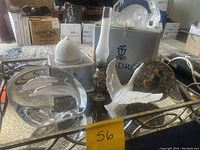 Overview of the lot showing all items on a mirrored tray including two lead crystal sculptures, Lladro boxes, oil lamp, and silver-toned decor