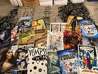 Overview photo showing the full lot of 13 promotional posters with varied colorful designs and signatures