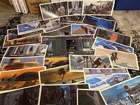 Overview of multiple vintage Star Wars art prints arranged on floor, diverse scenes and characters from original trilogy