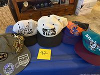 All five vintage baseball hats arranged on a table, showing various team logos and colors.