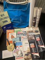 Blue American Airlines travel bag with travel brochures, maps, and medallion keychain displayed
