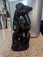 Front perspective view of hand-carved ebony tree of life sculpture approximately 8 inches tall.