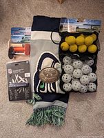 Photo showing golf practice tees, golf balls in mesh bags, Seahawks scarf, Jack Daniels belt buckle, and multi tool in packaging.