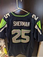 Back of the jersey showing 'SHERMAN' and number '25' with Seattle Seahawks team colors black, neon green, and white.