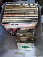 Top view showing a large stack of vinyl LP records and smaller stack of EP/45 singles in a plastic bin