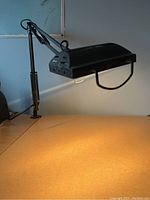 Desk lamp mounted and turned on, showing light cast on desk surface