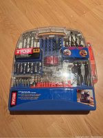 Overall kit showing all 90 pieces neatly organized in the blue plastic storage case under a transparent lid on wooden floor.