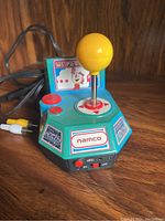 Front view of the Namco Ms. Pac-Man plug and play game showing joystick, buttons, and branding.