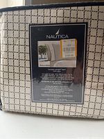 Photo of the Nautica queen sheet set label with dimensions and material details visible, showing 100% cotton and product pricing sticker.